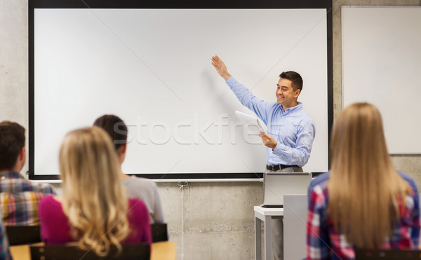 Stock photo: group of students and smiling teacher with notepad