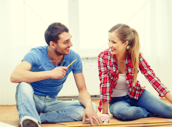 smiling couple measuring wood flooring Stock photo © dolgachov