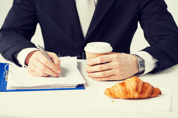businessman with coffee writing something Stock photo © dolgachov