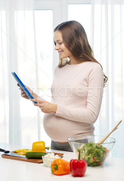 happy pregnant woman with tablet pc cooking food Stock photo © dolgachov