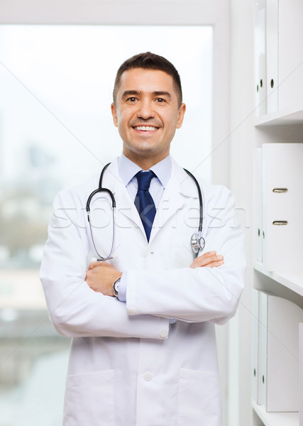 Stock photo: smiling doctor in white coat at medical office