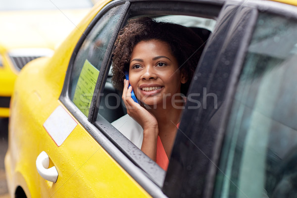 Szczęśliwy Afryki kobieta wzywając smartphone taksówką Zdjęcia stock © dolgachov