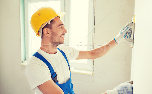 smiling builder with grinding tool indoors Stock photo © dolgachov