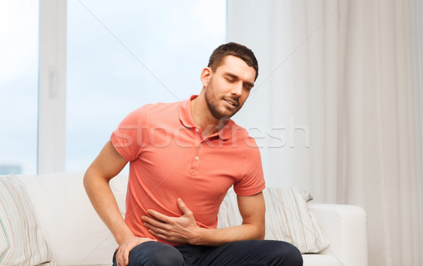 Nieszczęśliwy człowiek cierpienie ból brzucha domu ludzi Zdjęcia stock © dolgachov