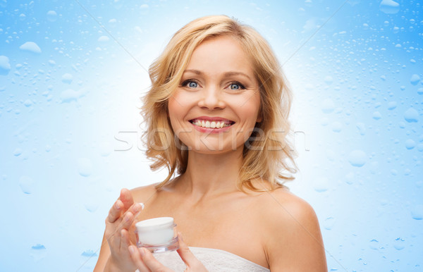 happy middle aged woman with moisturizing cream Stock photo © dolgachov