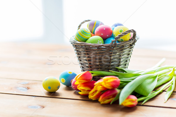 close up of easter eggs in basket and flowers Stock photo © dolgachov