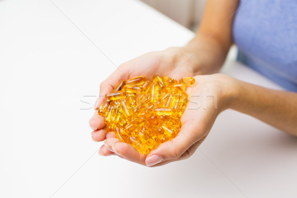 close up of woman hands holding pills or capsules Stock photo © dolgachov