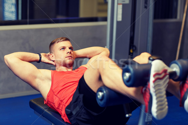 young man making abdominal exercises in gym Stock photo © dolgachov