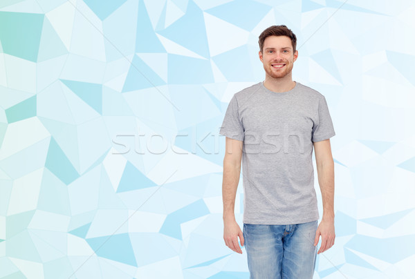 Gelukkig glimlachend jonge man grijs tshirt jeans Stockfoto © dolgachov