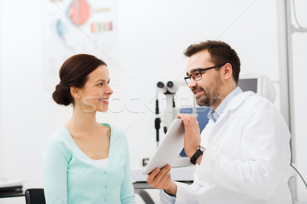 optician with tablet pc and patient at eye clinic Stock photo © dolgachov