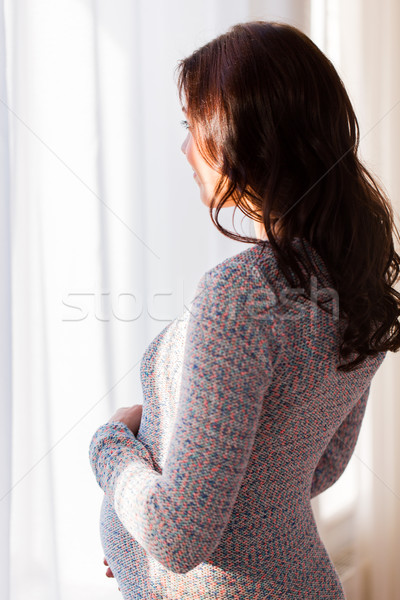 close up of happy pregnant woman looking to window Stock photo © dolgachov