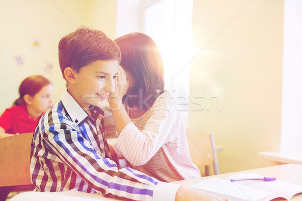 smiling schoolgirl whispering to classmate ear Stock photo © dolgachov