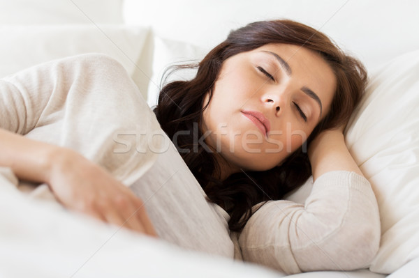 Stock photo: young woman sleeping in bed at home