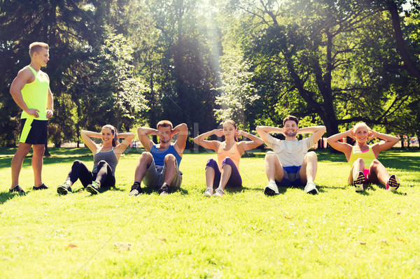 group of friends or sportsmen exercising outdoors Stock photo © dolgachov