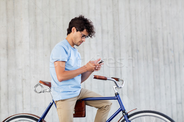 man with smartphone and fixed gear bike on street Stock photo © dolgachov