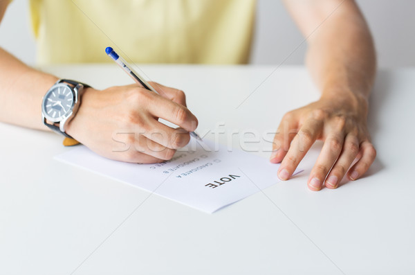 Stock photo: close up of hands with vote or ballot on election