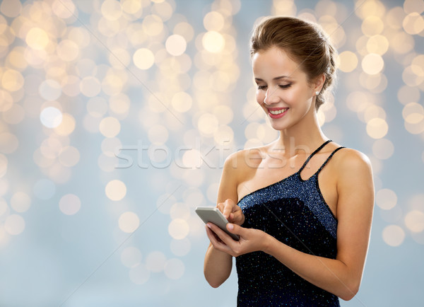 Femeie zambitoare rochie de seara smartphone tehnologie comunicare oameni Imagine de stoc © dolgachov
