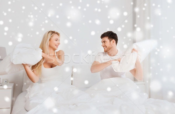 Heureux couple bataille d'oreillers lit maison personnes [[stock_photo]] © dolgachov