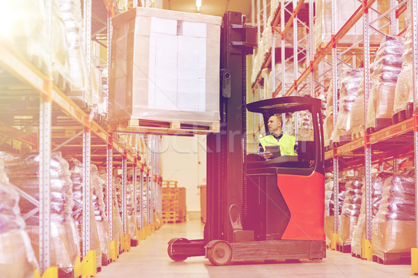 man with tablet pc operating forklift at warehouse Stock photo © dolgachov