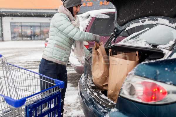 woman loading food from shopping cart to car trunk Stock photo © dolgachov