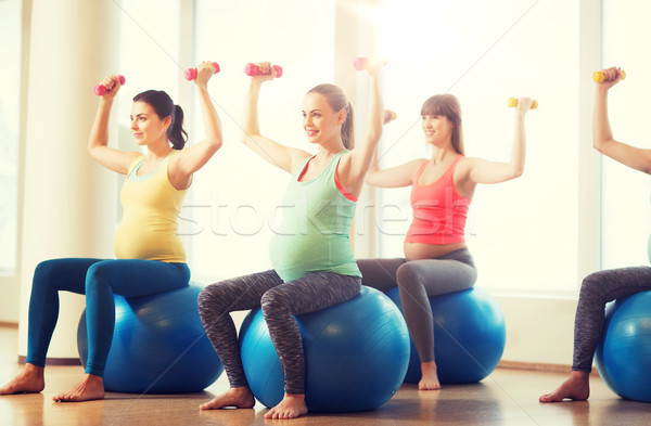 happy pregnant women exercising on fitball in gym Stock photo © dolgachov