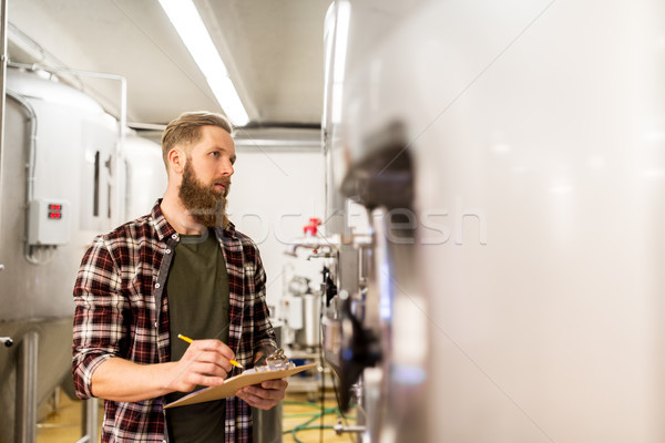 Stock photo: man with clipboard at craft brewery or beer plant