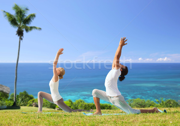 couple making yoga in low lunge pose outdoors Stock photo © dolgachov