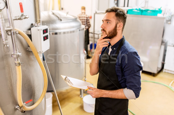 Om clipboard fabrica de bere bere plantă oameni de afaceri Imagine de stoc © dolgachov