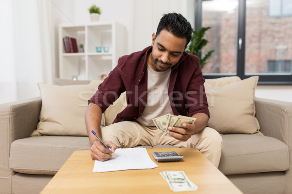 man with money and calculator filling papers Stock photo © dolgachov