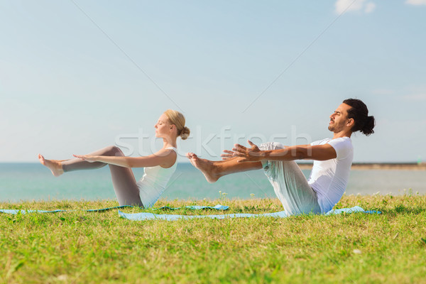 Sonriendo Pareja yoga aire libre fitness Foto stock © dolgachov