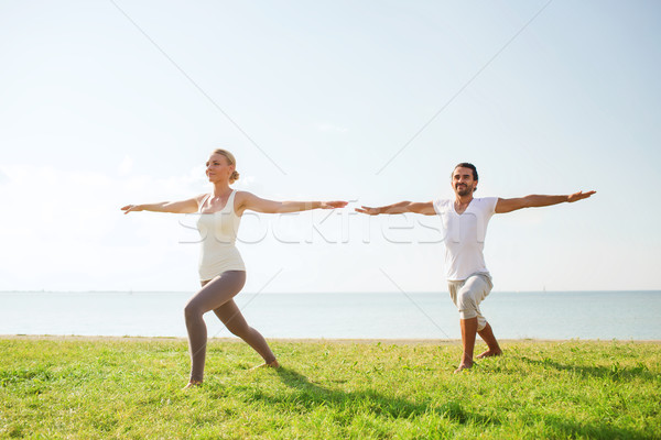 smiling couple making yoga exercises outdoors Stock photo © dolgachov