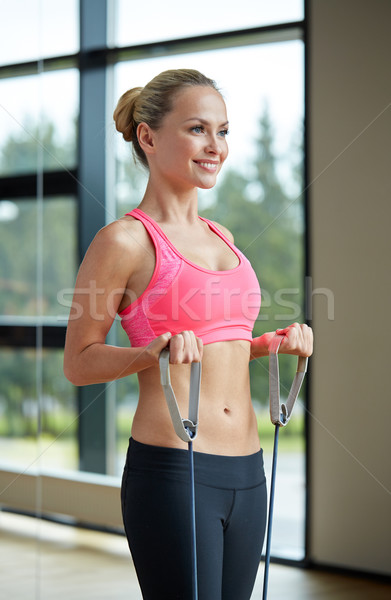 smiling woman with expander in gym Stock photo © dolgachov