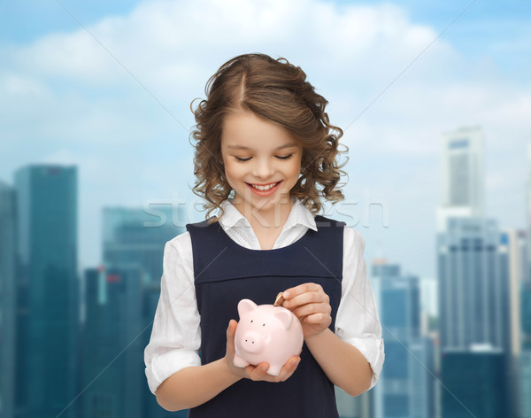 happy girl putting coin into piggy bank Stock photo © dolgachov