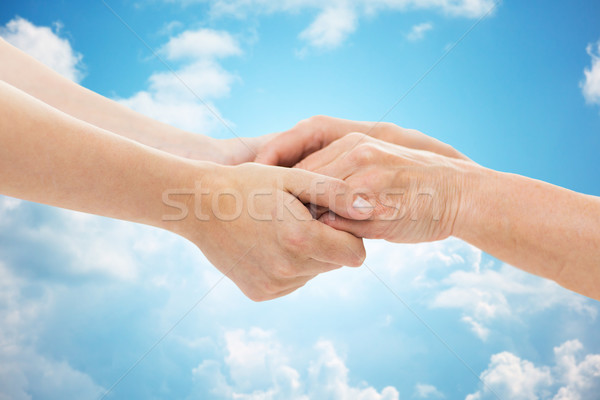 close up of senior and young woman holding hands Stock photo © dolgachov