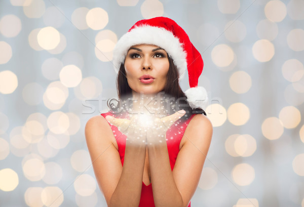 beautiful sexy woman in santa hat blowing on palms Stock photo © dolgachov