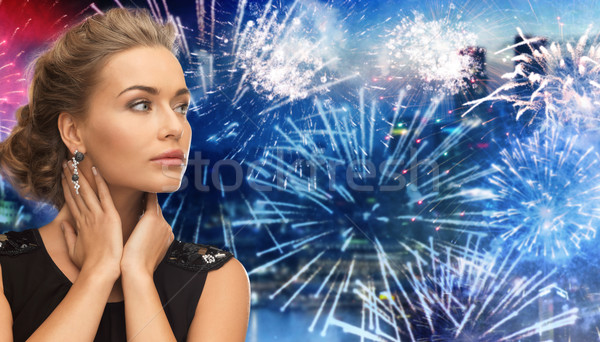 beautiful woman wearing earrings over firework Stock photo © dolgachov