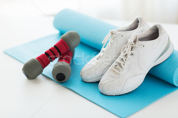 close up of sneakers, dumbbells and sports mat Stock photo © dolgachov