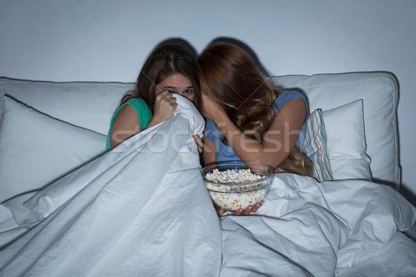 scared teenage girls watching horror on tv at home Stock photo © dolgachov