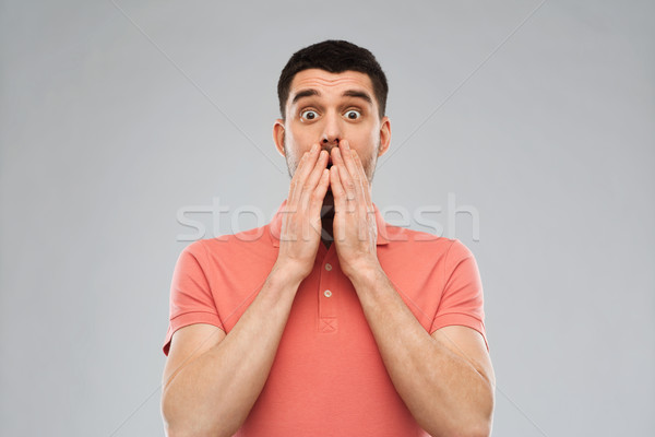 scared man in polo t-shirt over gray background Stock photo © dolgachov