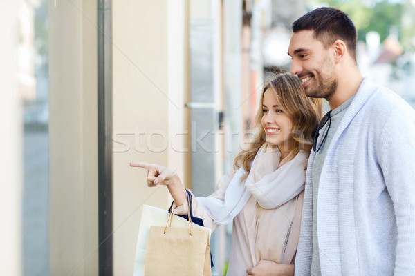 happy couple with shopping bags at shop window Stock photo © dolgachov