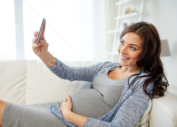 pregnant woman taking smartphone selfie at home Stock photo © dolgachov