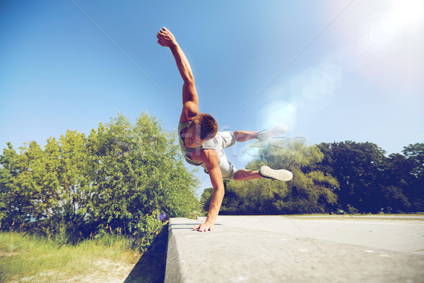 sporty young man jumping in summer park Stock photo © dolgachov