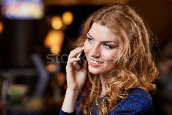 young woman with smartphone at night club or bar Stock photo © dolgachov