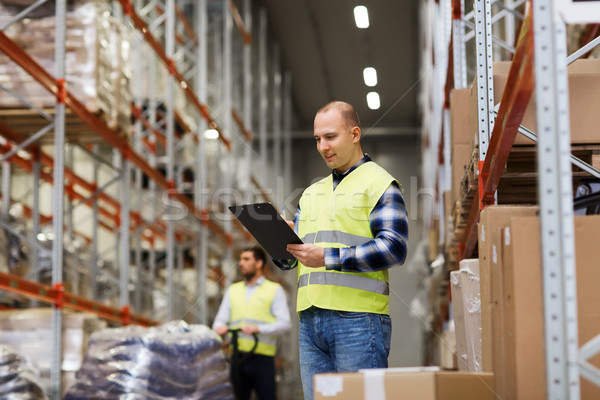 man with clipboard in safety vest at warehouse Stock photo © dolgachov