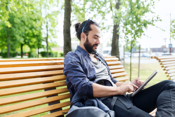 man with tablet pc sitting on city street bench Stock photo © dolgachov