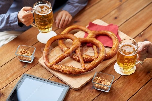 close up of man drinking beer with pretzels at pub Stock photo © dolgachov