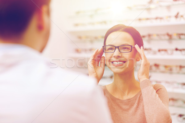 woman showing glasses to optician at optics store Stock photo © dolgachov