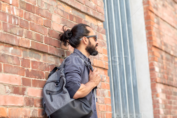 Hombre mochila pie calle de la ciudad pared viaje Foto stock © dolgachov