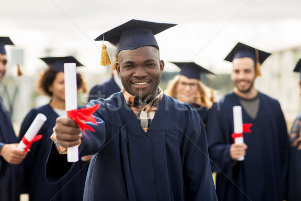 Stock photo: happy students in mortar boards with diplomas