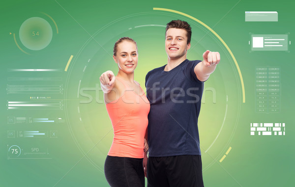 happy sportive man and woman pointing finger Stock photo © dolgachov